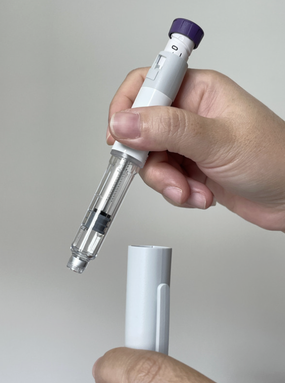 A patient holding a GLP-1 injection pen